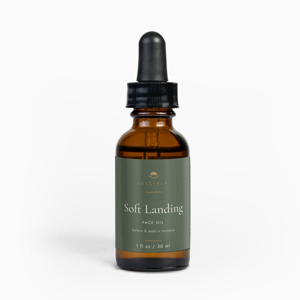 Solstela Soft Landing face oil, amber glass dropper bottle with a sage-green label, on a plain pale background